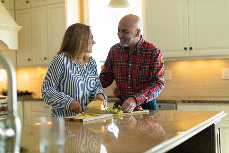 Carlos and Tatiana Ibanez stand in their kitchen preparing cheese and grapes