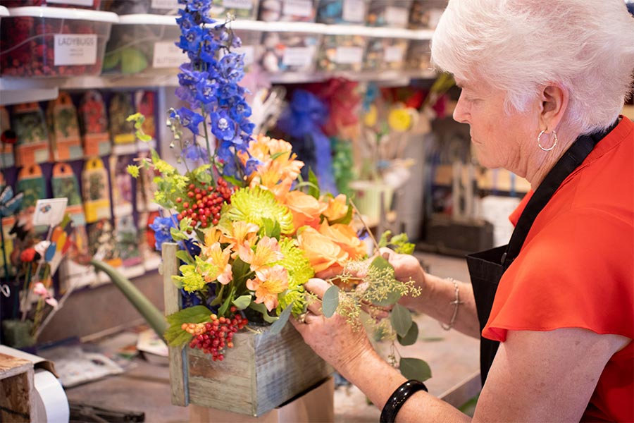 Barronelle Stutzman arranges a bouquet of flowers in a wooden box at Arlene's Flowers.